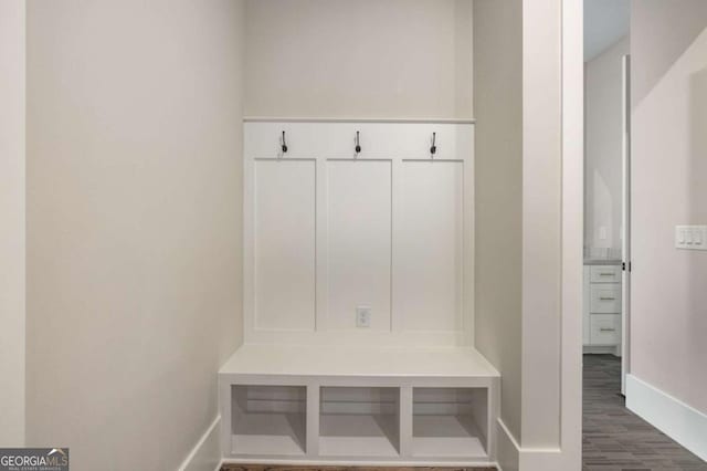 mudroom with dark wood-style floors and baseboards