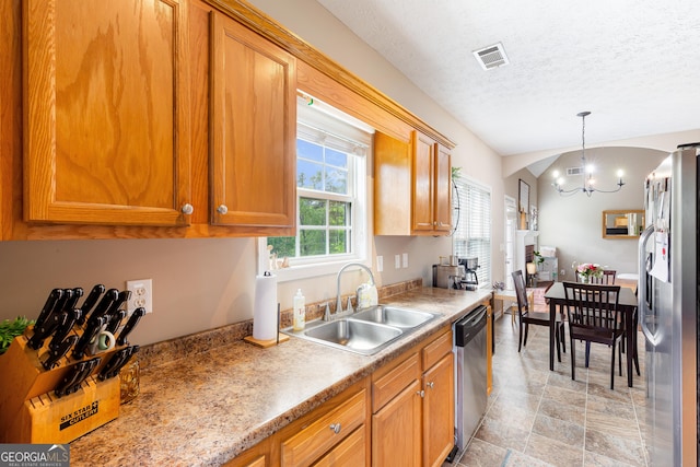 kitchen featuring brown cabinets, a sink, appliances with stainless steel finishes, and visible vents