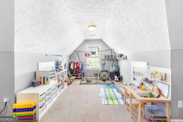 game room featuring a textured ceiling, carpet flooring, and vaulted ceiling