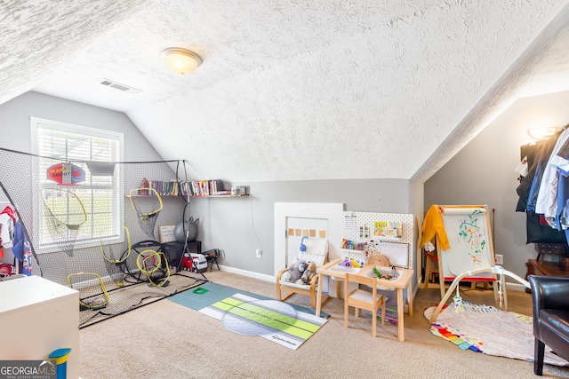 playroom with lofted ceiling, visible vents, baseboards, a textured ceiling, and carpet floors