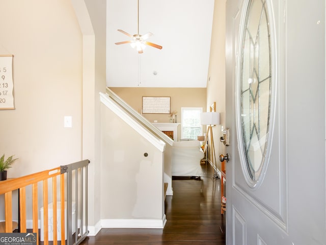 entryway with dark wood-style flooring, ceiling fan, baseboards, a towering ceiling, and arched walkways