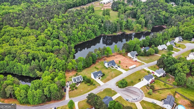 drone / aerial view featuring a wooded view and a water view