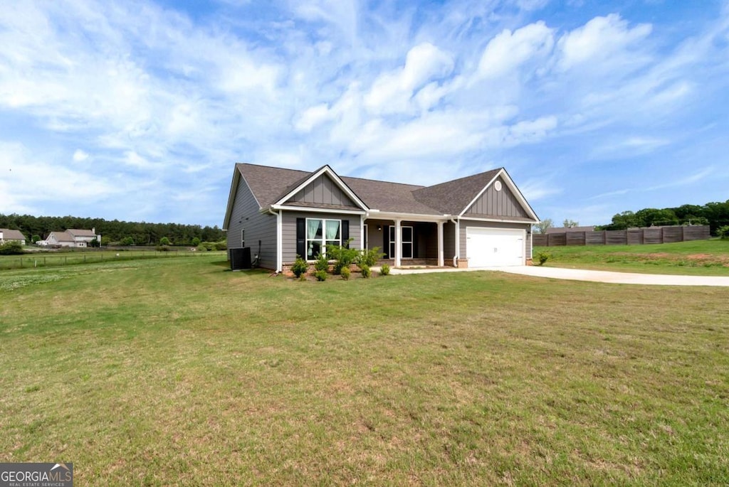 view of front of house featuring fence, board and batten siding, driveway, and an attached garage