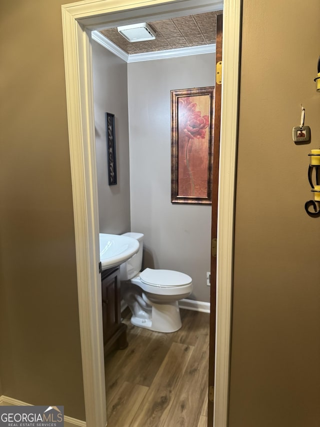 1685 Bailey Creek Rd SW, Conyers, GA 30094 - half bath featuring crown molding, toilet, wood finished floors, and vanity