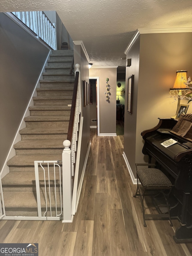 1685 Bailey Creek Rd SW, Conyers, GA 30094 - hall with a textured ceiling, ornamental molding, wood finished floors, and stairway