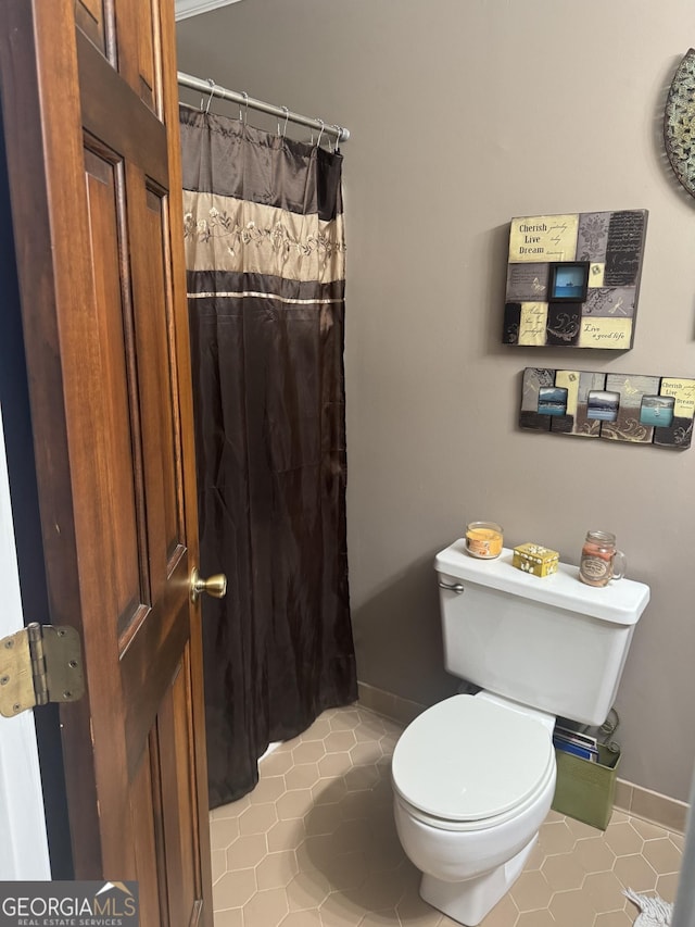 1685 Bailey Creek Rd SW, Conyers, GA 30094 - bathroom with baseboards, a shower with shower curtain, tile patterned floors, and toilet
