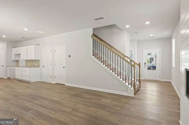 entryway featuring wood finished floors, recessed lighting, baseboards, and stairs