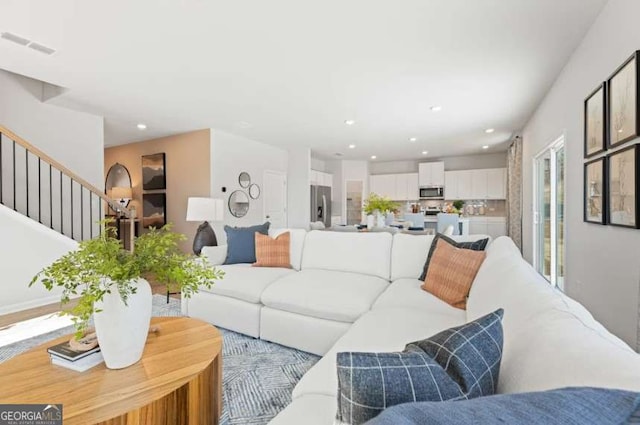 living room with recessed lighting, visible vents, and stairway