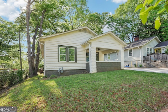 bungalow-style house featuring ceiling fan, fence, and a front yard