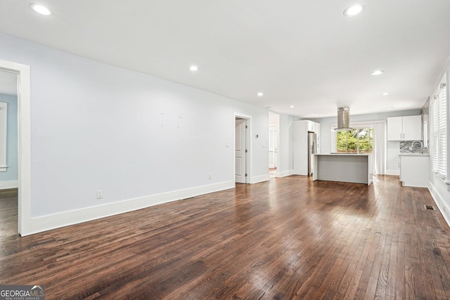 unfurnished living room featuring recessed lighting, baseboards, and dark wood-style floors
