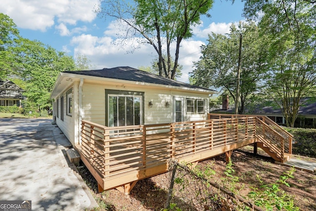 rear view of property featuring a wooden deck