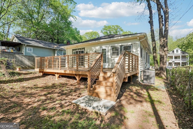 rear view of house featuring a deck and fence