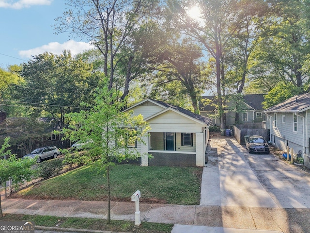 bungalow-style home featuring brick siding, driveway, and a front lawn