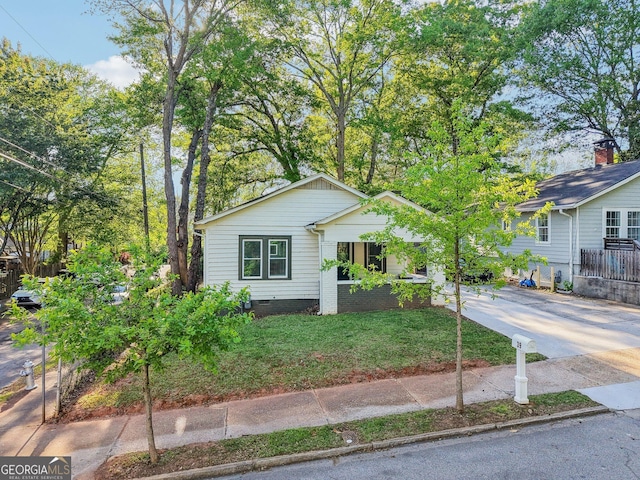view of front of house featuring concrete driveway and a front lawn