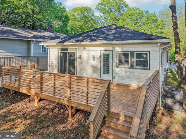 back of house featuring a shingled roof, fence, a wooden deck, and central AC unit