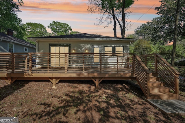 back of property at dusk with a deck