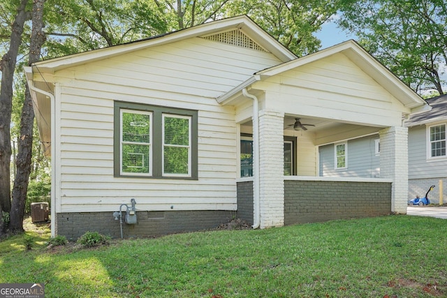 view of front of house with crawl space, a ceiling fan, and a front lawn