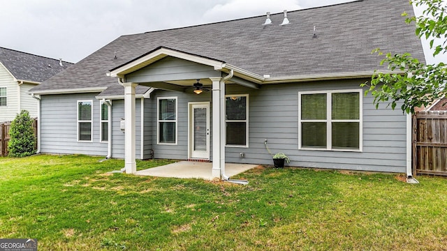 back of property with a lawn, a ceiling fan, a patio area, and fence