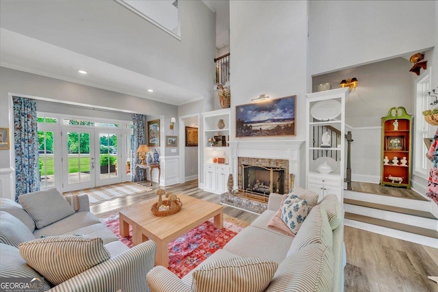 205 River Forest Dr, Forsyth, GA 31029 - living room with a fireplace, french doors, recessed lighting, wood finished floors, and a towering ceiling