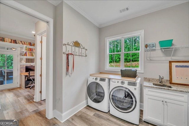 205 River Forest Dr, Forsyth, GA 31029 - clothes washing area with crown molding, cabinet space, a sink, light wood-style floors, and separate washer and dryer
