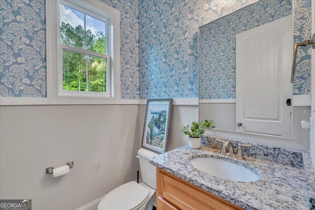 205 River Forest Dr, Forsyth, GA 31029 - bathroom featuring toilet, wallpapered walls, wainscoting, and vanity