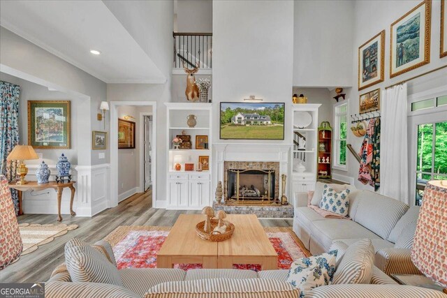 205 River Forest Dr, Forsyth, GA 31029 - living area with a towering ceiling, ornamental molding, wood finished floors, and a fireplace