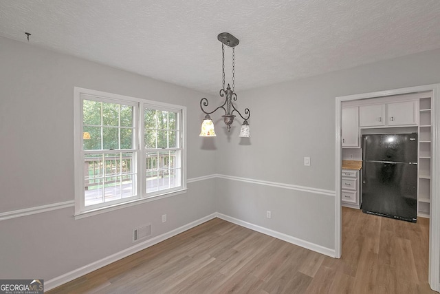 304 N Briar Rdg, Woodstock, GA 30189 - unfurnished dining area with baseboards, light wood-type flooring, a textured ceiling, and visible vents