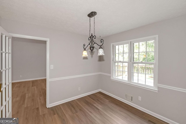 304 N Briar Rdg, Woodstock, GA 30189 - unfurnished dining area with visible vents, a textured ceiling, baseboards, and wood finished floors