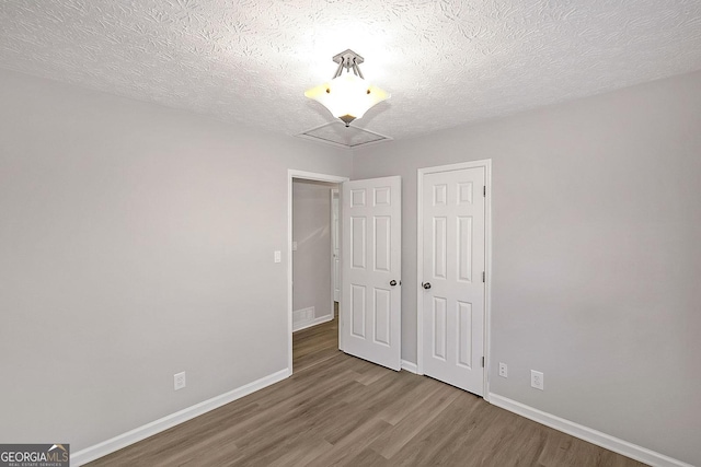 304 N Briar Rdg, Woodstock, GA 30189 - unfurnished bedroom featuring a textured ceiling, baseboards, a closet, and wood finished floors
