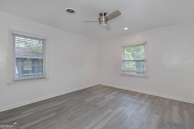 unfurnished room with visible vents, wood finished floors, and baseboards