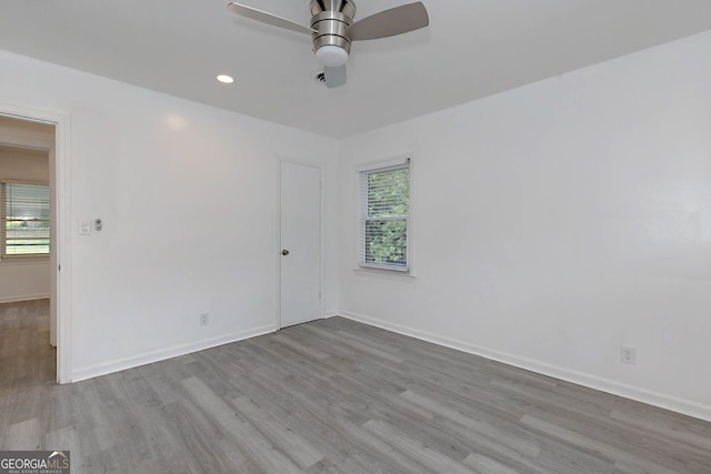 spare room featuring wood finished floors, plenty of natural light, and a ceiling fan