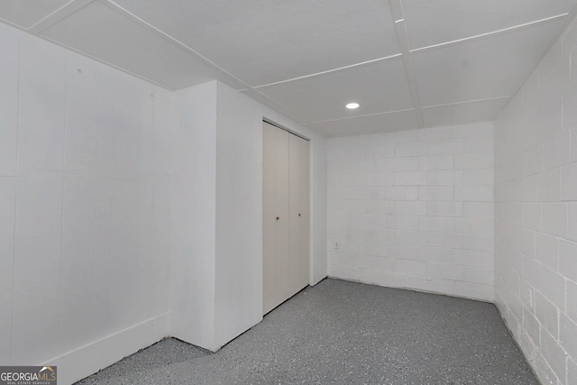 interior space with concrete block wall and recessed lighting