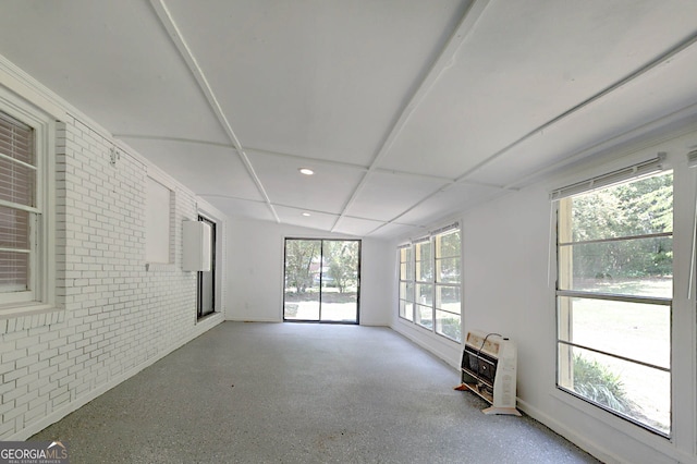 empty room featuring recessed lighting, heating unit, brick wall, speckled floor, and baseboards
