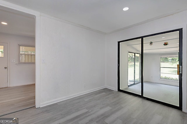 empty room with baseboards, recessed lighting, wood finished floors, and crown molding