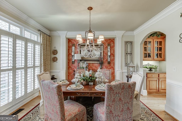 2930 Aquitania Ln, Cumming, GA 30040 - dining room featuring an inviting chandelier, light wood-type flooring, crown molding, a decorative wall, and wainscoting
