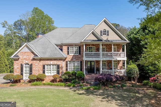 2930 Aquitania Ln, Cumming, GA 30040 - view of front of house featuring a balcony, a chimney, covered porch, a front yard, and brick siding