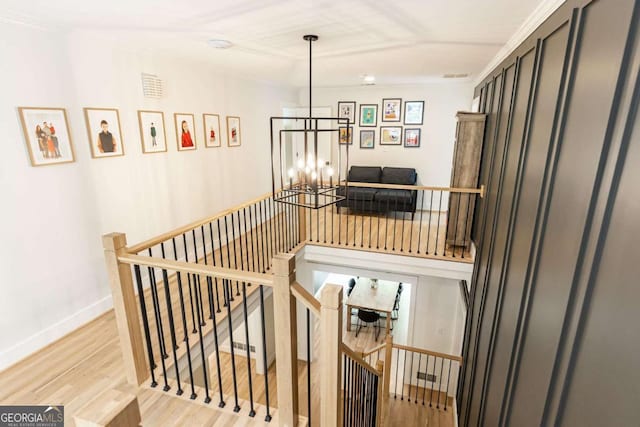 3380 Hill Forest Trl NW, Acworth, GA 30101 - stairway with an inviting chandelier, baseboards, wood finished floors, visible vents, and ornamental molding