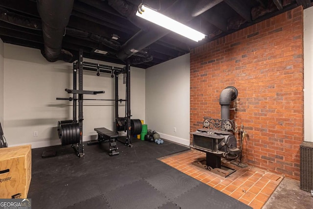 3380 Hill Forest Trl NW, Acworth, GA 30101 - workout room with baseboards, a wood stove, and brick wall