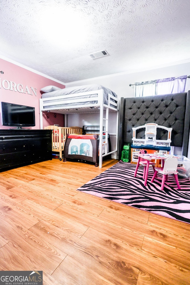 7415 Sierra Dr, Columbus, GA 31904 - bedroom with ornamental molding, a textured ceiling, visible vents, and wood finished floors
