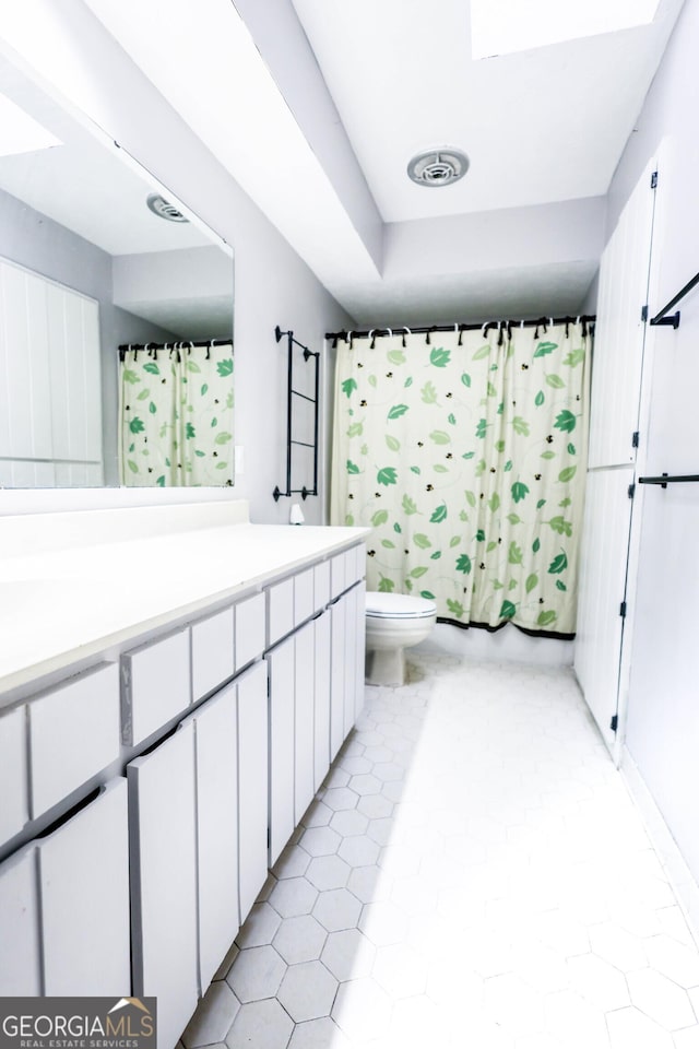 7415 Sierra Dr, Columbus, GA 31904 - full bath with visible vents, shower / tub combo with curtain, toilet, vanity, and tile patterned flooring