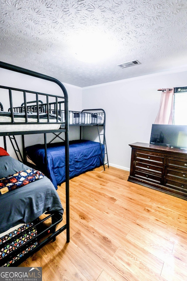 7415 Sierra Dr, Columbus, GA 31904 - bedroom featuring a textured ceiling, visible vents, wood finished floors, and baseboards