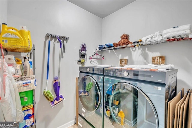 clothes washing area with washing machine and clothes dryer, laundry area, and baseboards