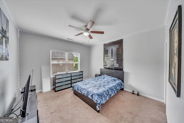 carpeted bedroom with visible vents, a ceiling fan, and baseboards