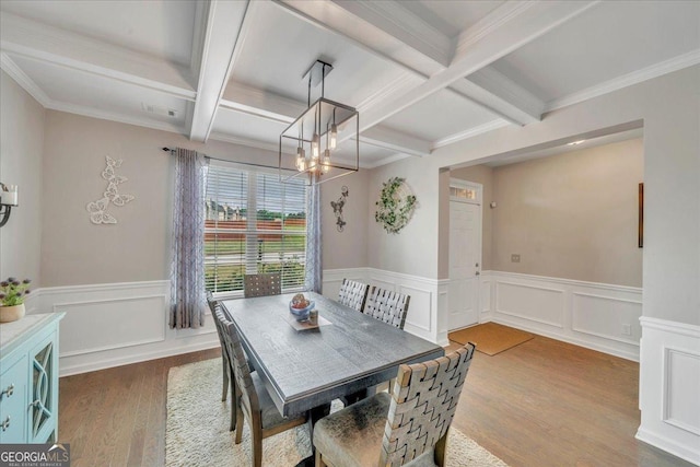 dining area featuring a chandelier, coffered ceiling, beam ceiling, wood finished floors, and wainscoting