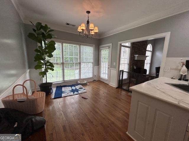 4665 Oakmont Bend Dr, Alpharetta, GA 30004 - dining area featuring ornamental molding, a chandelier, dark wood finished floors, and a fireplace