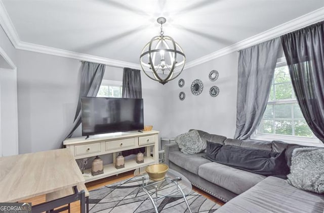 living room featuring crown molding, an inviting chandelier, and wood finished floors