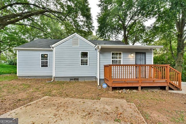 back of house with a deck and a patio