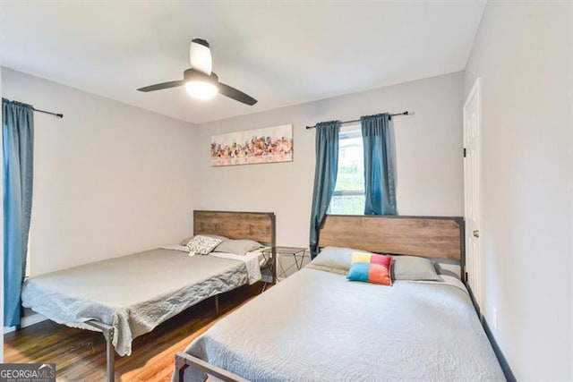 bedroom featuring baseboards, wood finished floors, and a ceiling fan