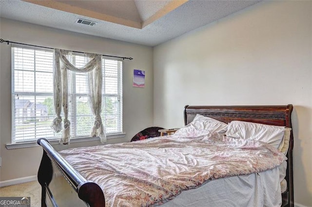bedroom with baseboards, visible vents, and light carpet