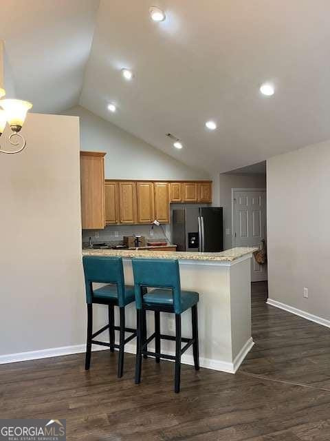 220 Rehobeth Way, Fayetteville, GA 30214 - kitchen featuring fridge with ice dispenser, baseboards, a peninsula, a breakfast bar, and dark wood-type flooring